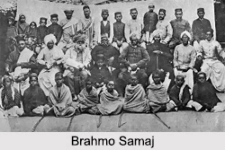 19वीं सदी के ब्रह्मो समाज की एक ऐतिहासिक सभा का चित्रण, जिसमें एक भव्य औपनिवेशिक भवन के सामने राजा राम मोहन राय सहित कई सुधारक पारंपरिक भारतीय परिधानों में एकत्रित हैं और सामाजिक-धार्मिक चर्चा कर रहे हैं।